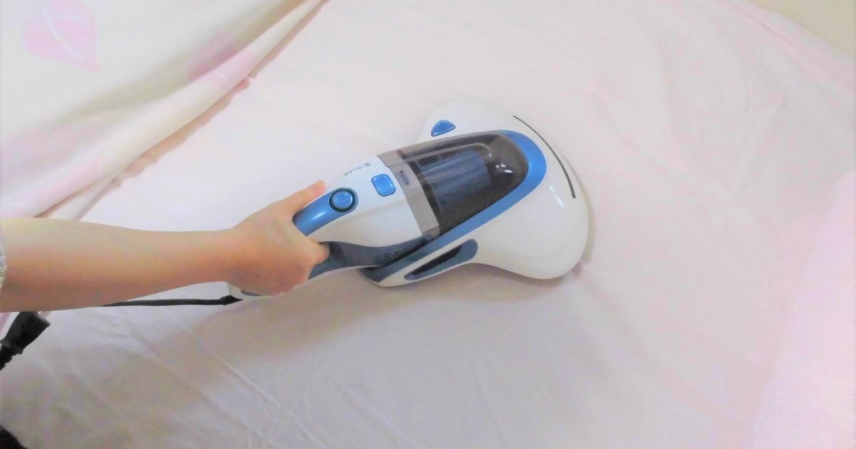 マットレス表面に掃除機をかけている画像