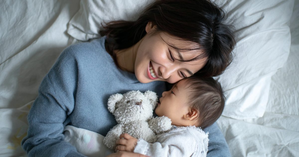 赤ちゃんと嬉しそうに添い寝するお母さん